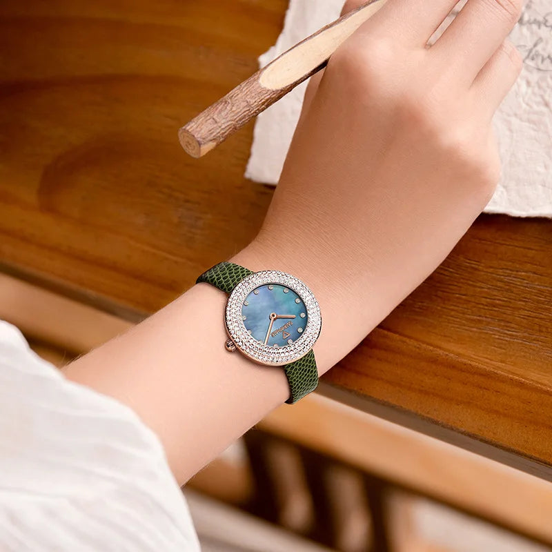 Lifestyle shot – Mark Fairwhale DIAMÉRA green strap diamond watch on wrist, writing at desk