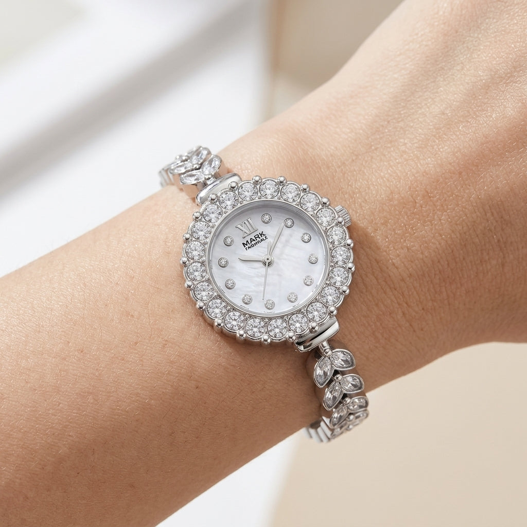 Silver wristwatch with gemstone accents on a wrist against a neutral background