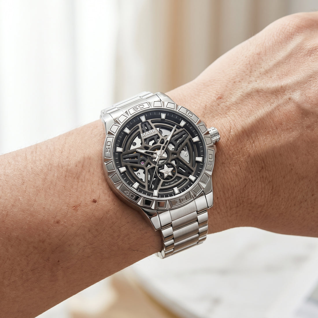 Silver wristwatch with intricate design on a person&