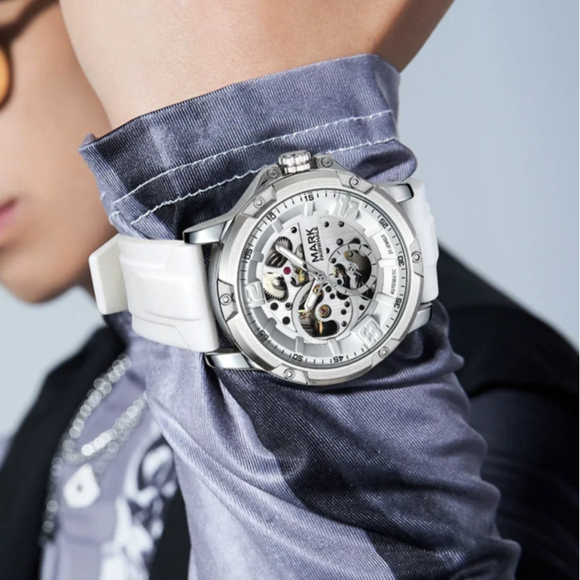 Stylish man wearing the Mark Fairwhale TURBIX skeleton automatic watch with white rubber strap, luxury lifestyle wristwatch photography.