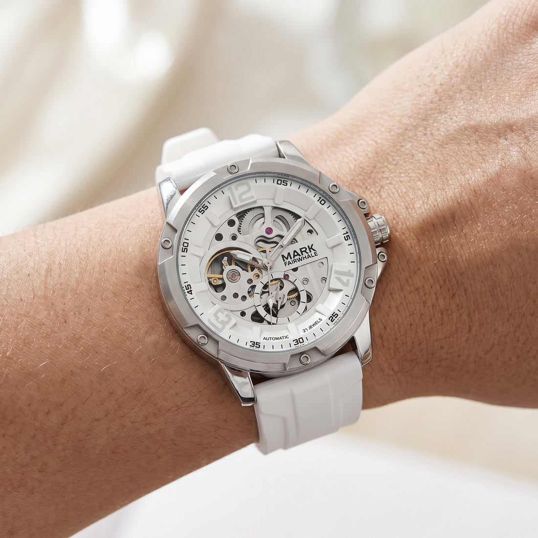 White wristwatch with visible brand name on a wrist against a neutral background