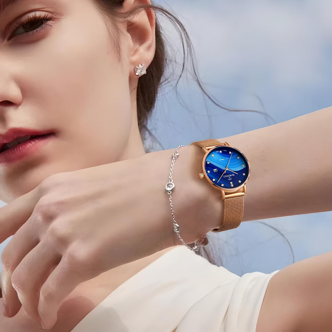 Woman wearing Mark Fairwhale 3240 ELARIA blue dial quartz watch with rose gold mesh strap.