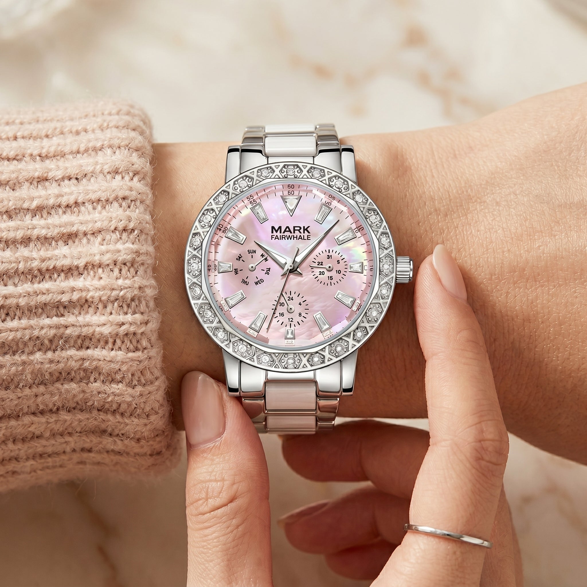 Mark Fairwhale women’s silver watch with pink mother of pearl dial and diamond bezel on wrist, luxury close-up