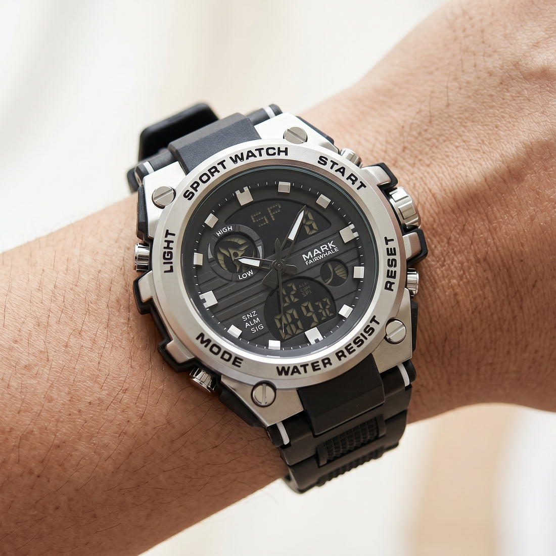 Black and silver sports watch on a wrist with a light background