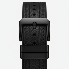 Black leather watch strap with buckle on a light gray background