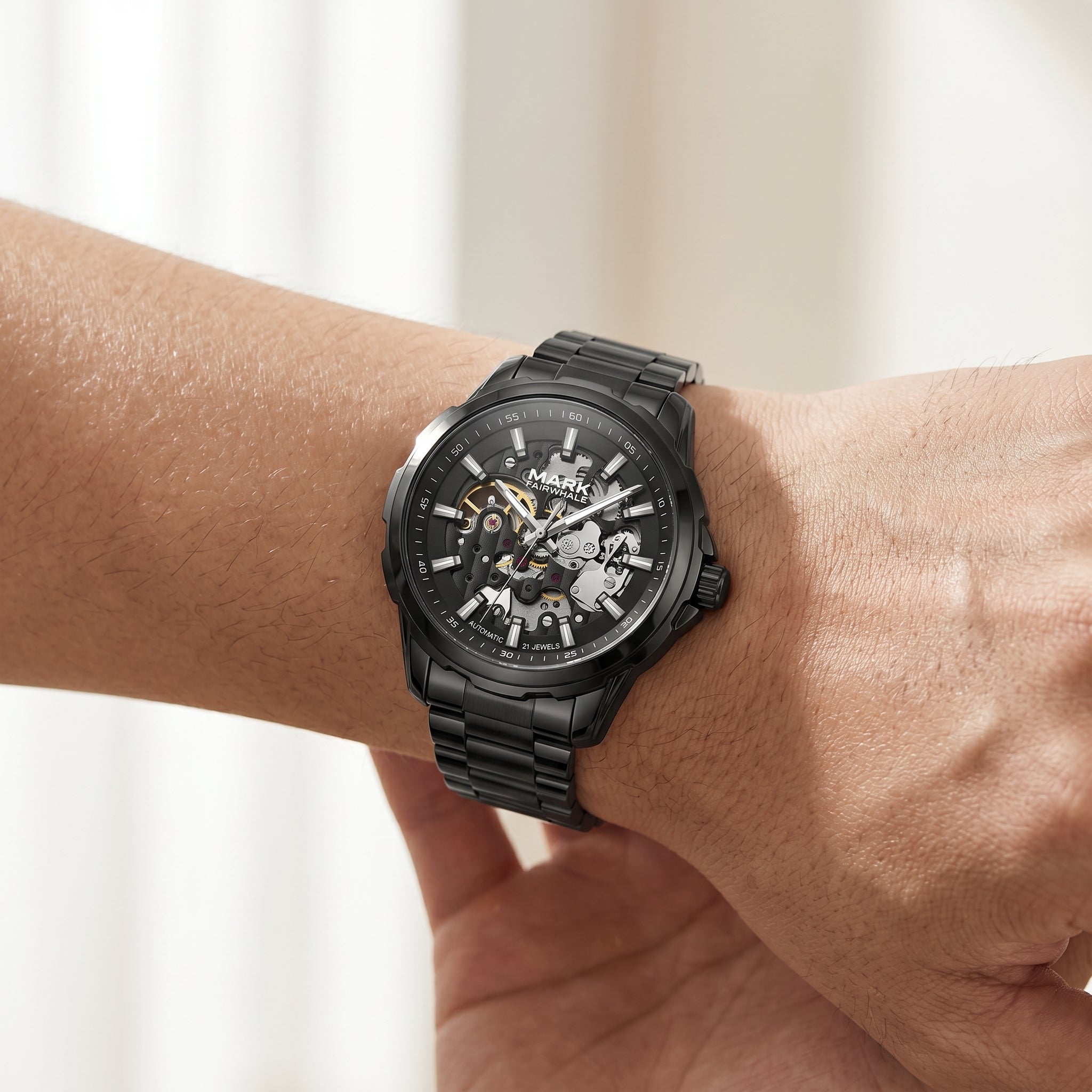 Black mechanical watch on a wrist with a blurred background