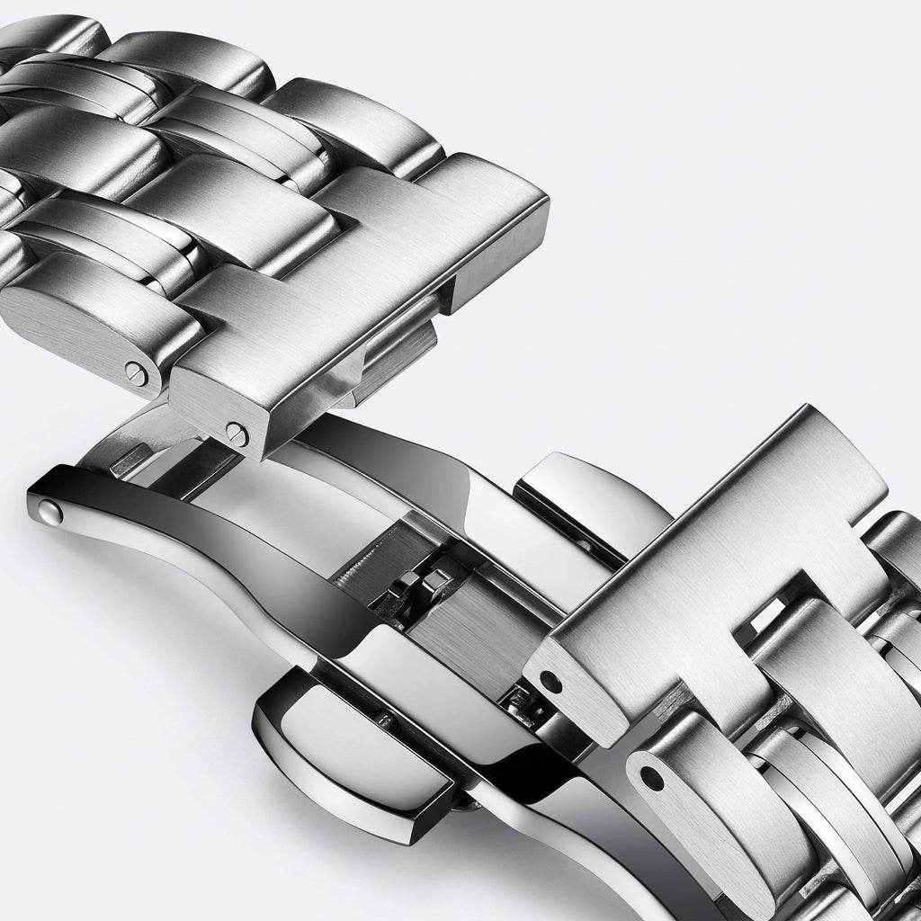 Close-up of a silver metal watch strap on a light gray background