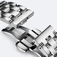 Close-up of a silver metal watch strap on a light gray background