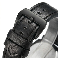 Close-up of a black leather watch strap with buckle on a white background