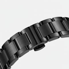 Close-up of a black metal watch strap on a light gray background