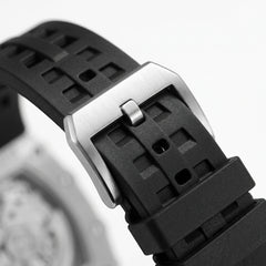 Close-up of a black waatch strap with a silver buckle on a blurred background