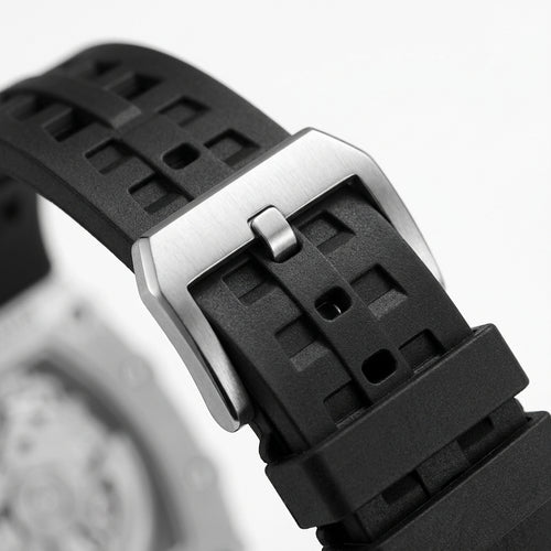 Close-up of a black waatch strap with a silver buckle on a blurred background