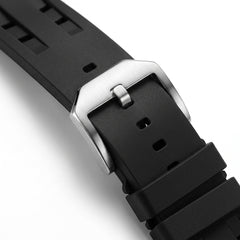 Close-up of a black watch strap with a silver buckle on a white background