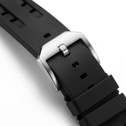 Close-up of a black watch strap with a silver buckle on a white background