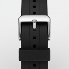 Close-up of a black watch straap with a silver buckle on a light gray background