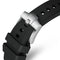 Close-up of a black watch strap with a silver clasp on a white background