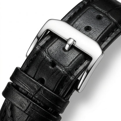 Close-up of a black leather watch strap with a silver buckle on a white background