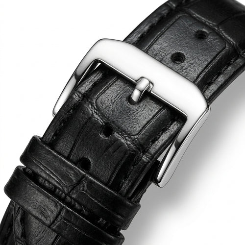Close-up of a black leather watch strap with a silver buckle on a white background