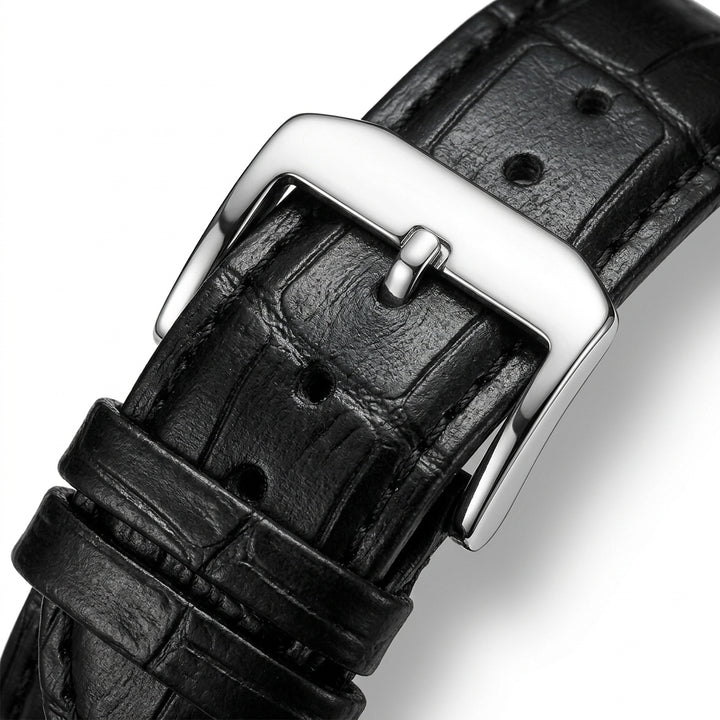 Close-up of a black leather watch strap with a silver buckle on a white background