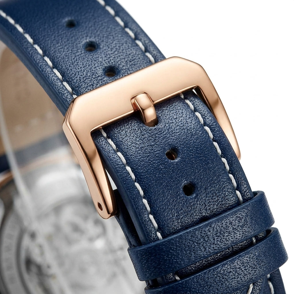 Close-up of a blue leather watch strap with a rose gold buckle on a blurred background