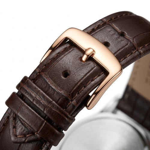 Close-up of a brown leather watch strap with a rose gold buckle on a white background