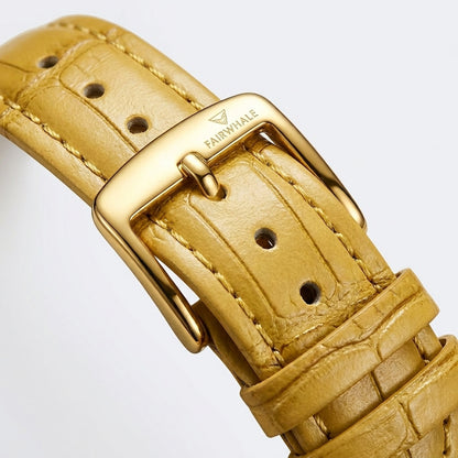 Close-up of a gold watch strap with a visible brand logo on a light gray background