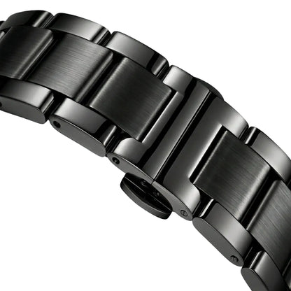Close-up of a metallic watch band on a light gray background