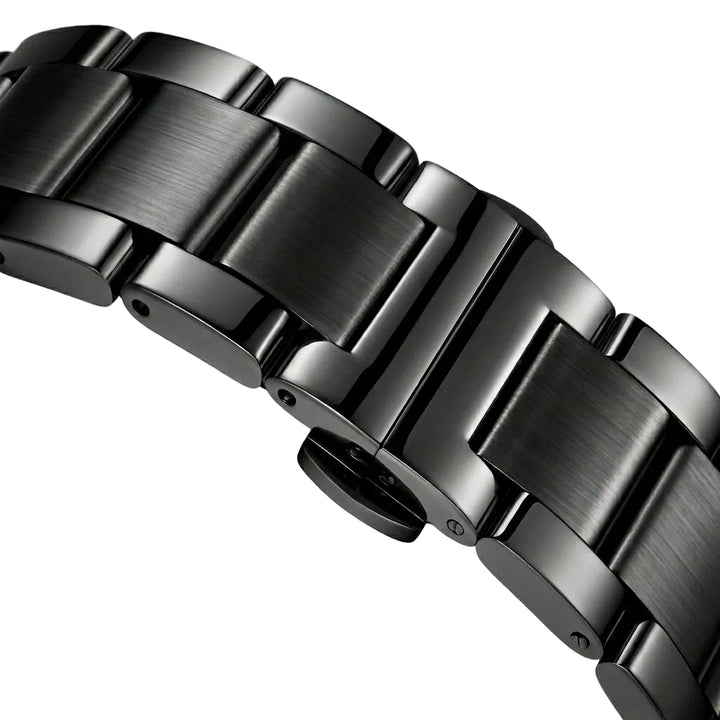 Close-up of a metallic watch band on a light gray background
