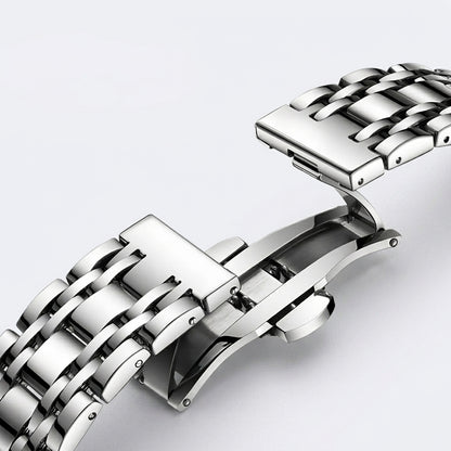 Close-up of a silver metal watch strap on a light gray background