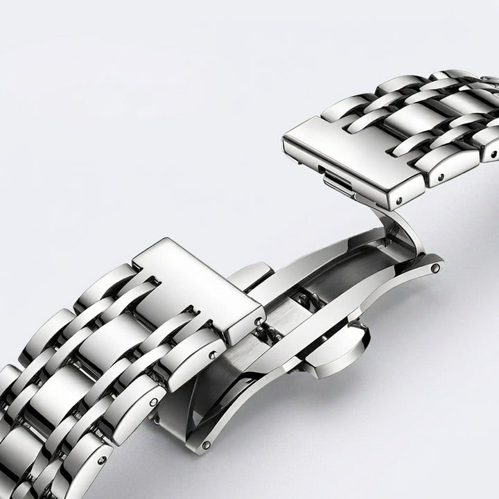Close-up of a silver metal watch strap on a light gray background
