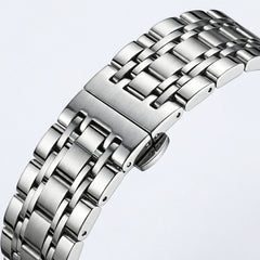 Close-up of a silver metal watch strap on a light gray background