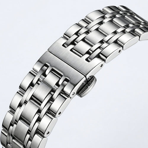 Close-up of a silver metal watch strap on a light gray background