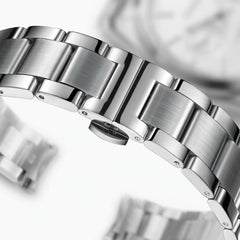 Close-up of a silver watch band with a blurred background