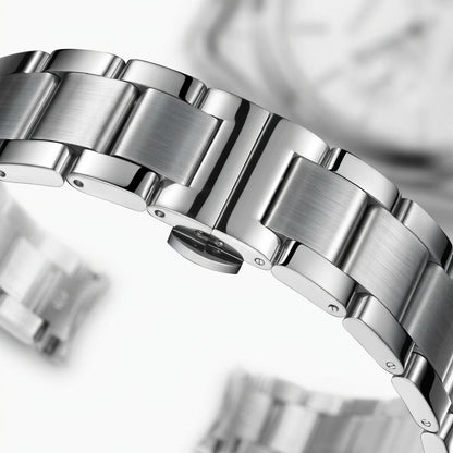 Close-up of a silver watch band with a blurred background