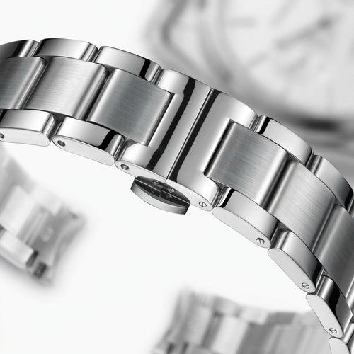 Close-up of a silver watch band with a blurred background