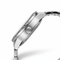 Close-up of a silver watch with detailed design on a white background