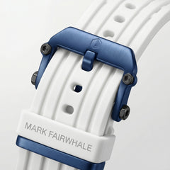 Close-up of a watch strap with blue buckle and 'Mark Fairwhale' branding on a light gray background