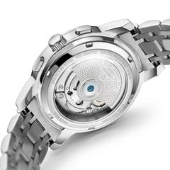 Close-up of the back of a stainless steel wristwatch with a transparent case, showing the automatic mechanical movement and bracelet on a white background.