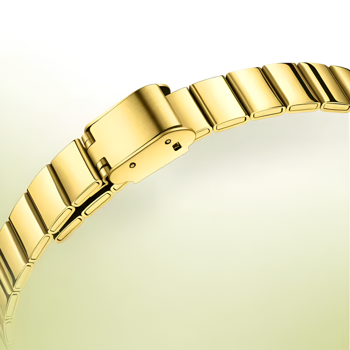 Gold bracelet on a light yellow background