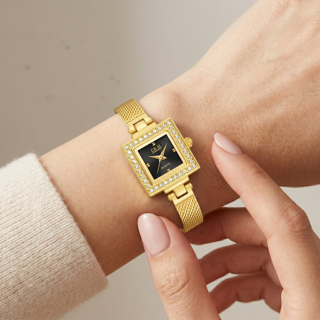 Gold wristwatch with diamond accents on a wrist against a neutral background