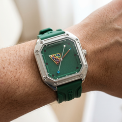 Green watch with a unique face on a wrist against a neutral background