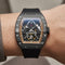 Luxury watch with a black strap on a wrist against a neutral background