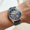 Luxury watch with blue face and leather strap on a wrist