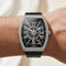 Luxury watch with diamond-studded case on a wrist against a neutral background