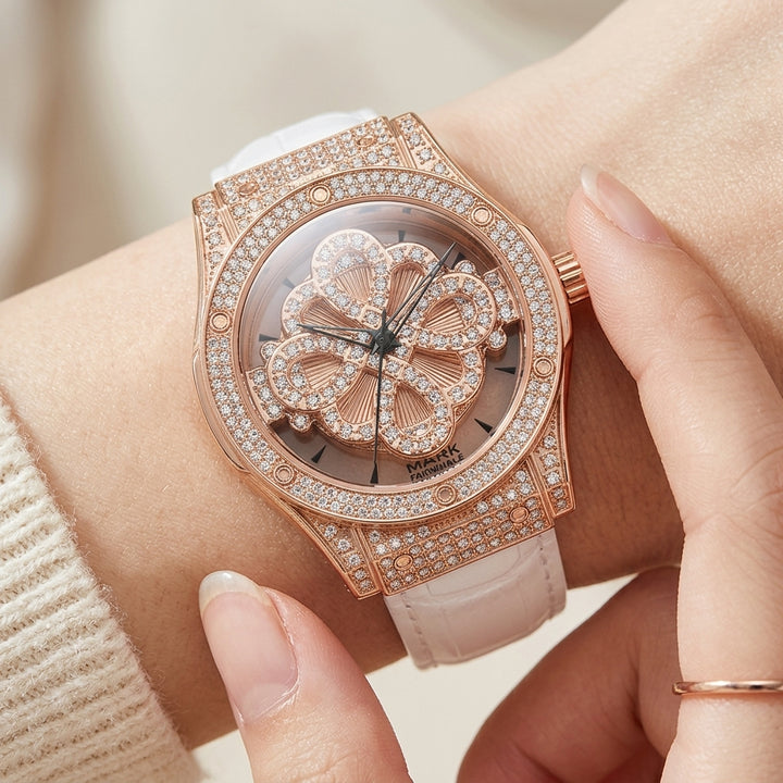 Luxury watch with rose gold case and white strap worn on wrist