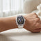 Luxury watch with transparent case on a person's wrist, blurred background