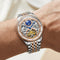 Luxury watch with visible mechanical components on a wrist against a neutral background