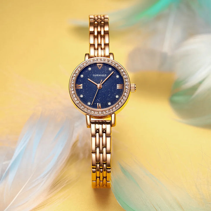 Mark Fairwhale LUMORA 3250 gold women’s quartz watch with starry dial and stainless steel bracelet – artistic shot with feathers