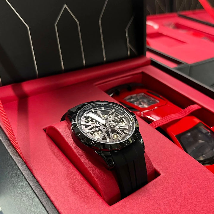 Mark Fairwhale black skeleton watch with sport design and black rubber strap displayed in premium red gift box alongside red sports car model