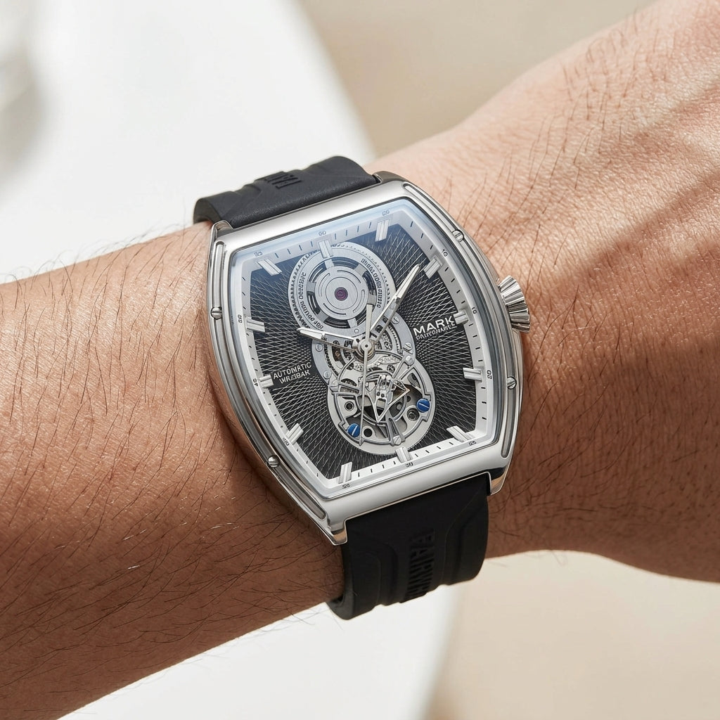 Mark Fairwhale men’s automatic skeleton watch with silver tonneau case, open heart dial and black rubber strap worn on wrist in close up lifestyle view